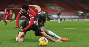 A tussle between Harry Maguire and Mohamed Salah sees both players go to ground