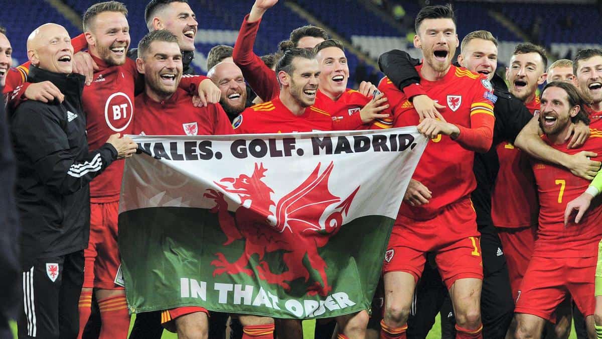 Футболисты сборной Уэльса празднуют победу над Венгрией в отборочном матче Евро - 2020. На флаге написано «Уэльс, гольф, Мадрид. В таком порядке» (Фото - Athena Pictures/Getty Images)